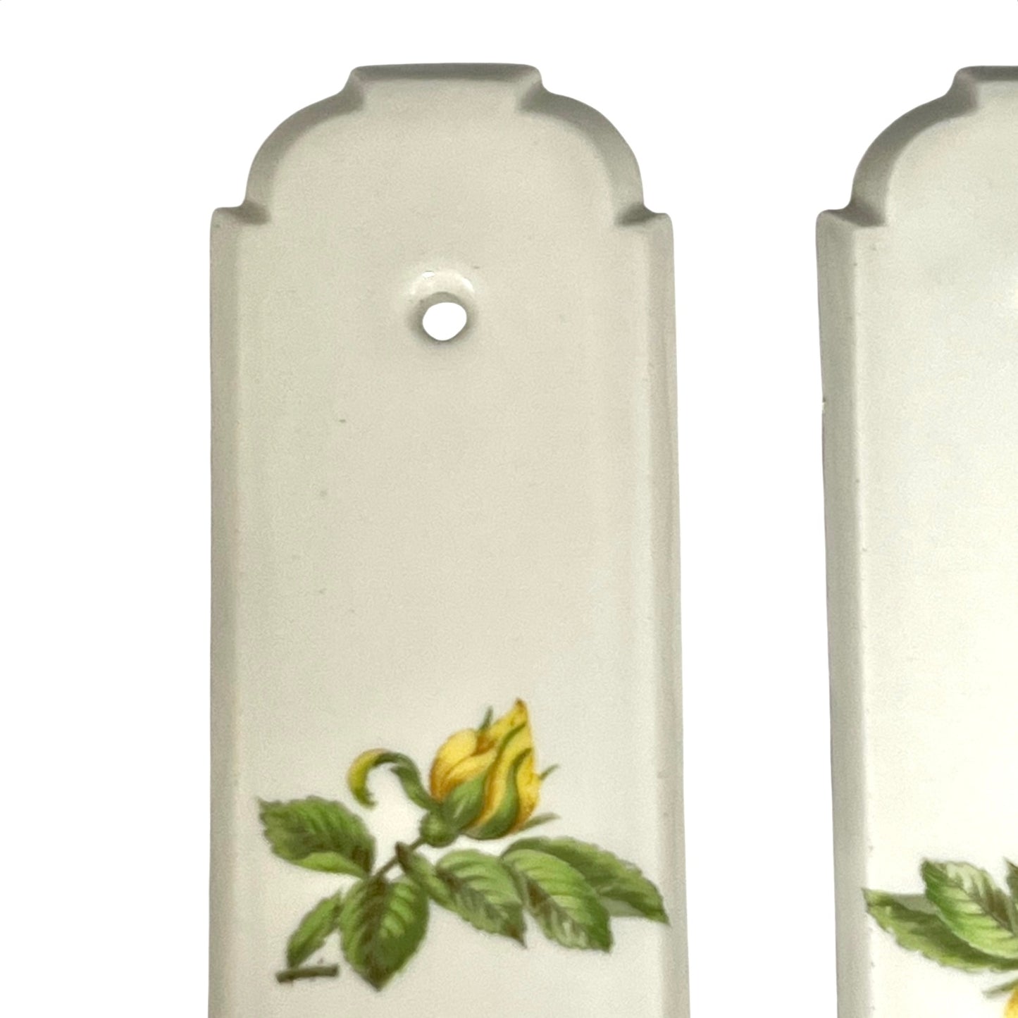 close up of door push plate with a yellow rose decoration on a white background