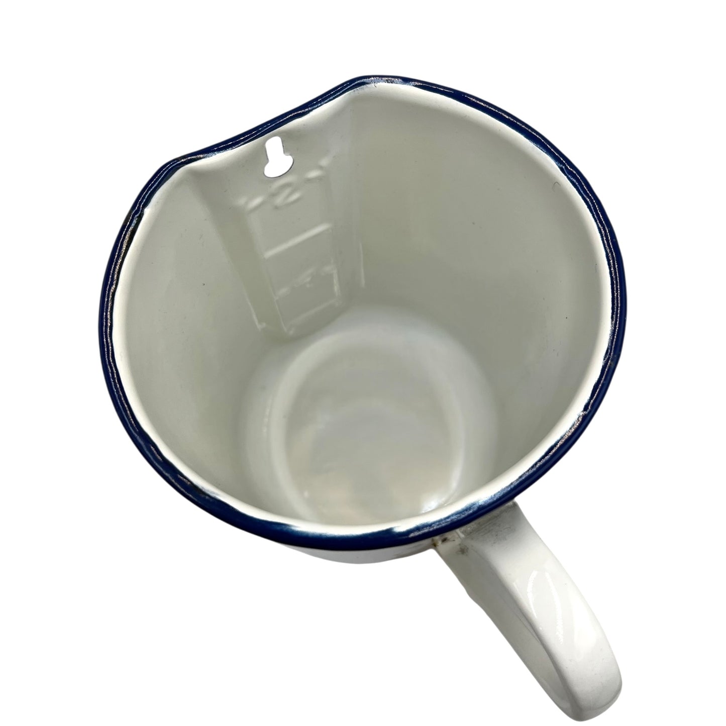 Inside view of white enamel jug with blue rim and spout on a white background