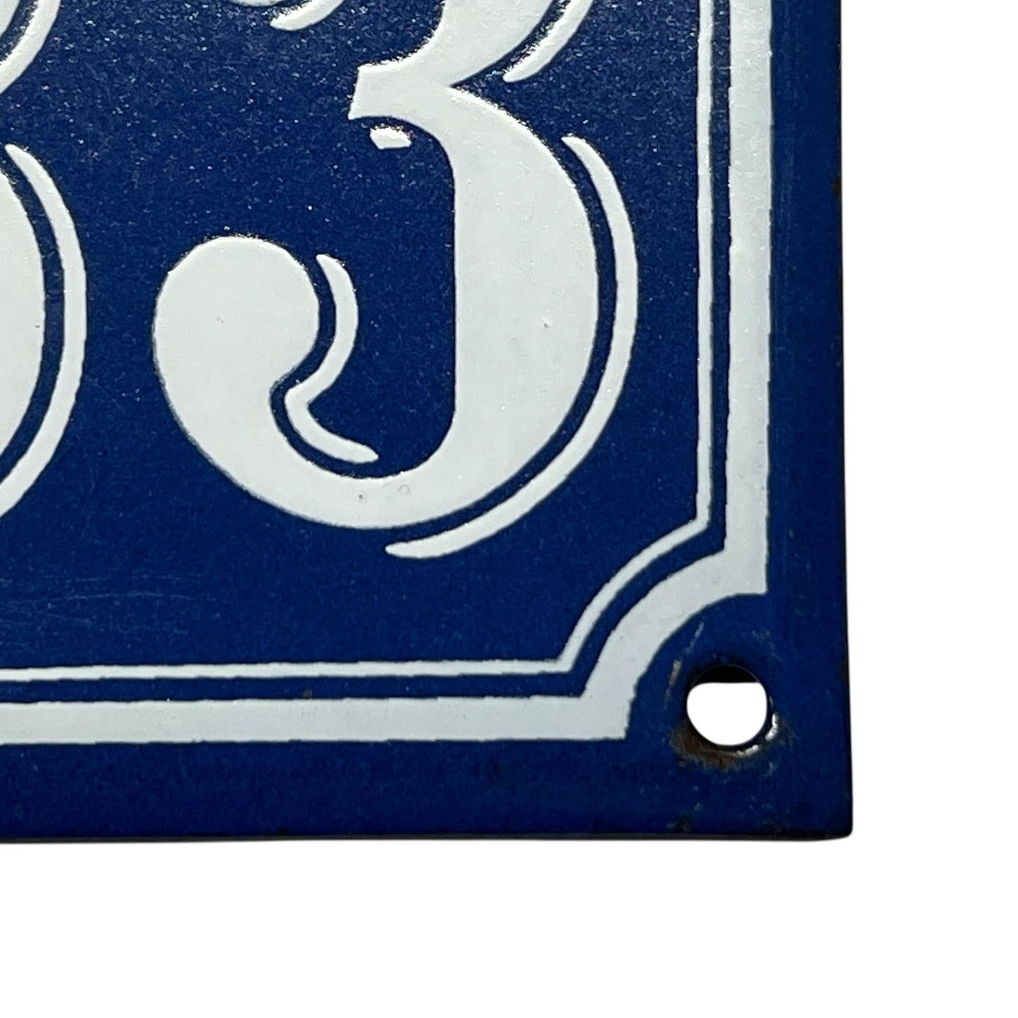 bottom corner of enamel door number