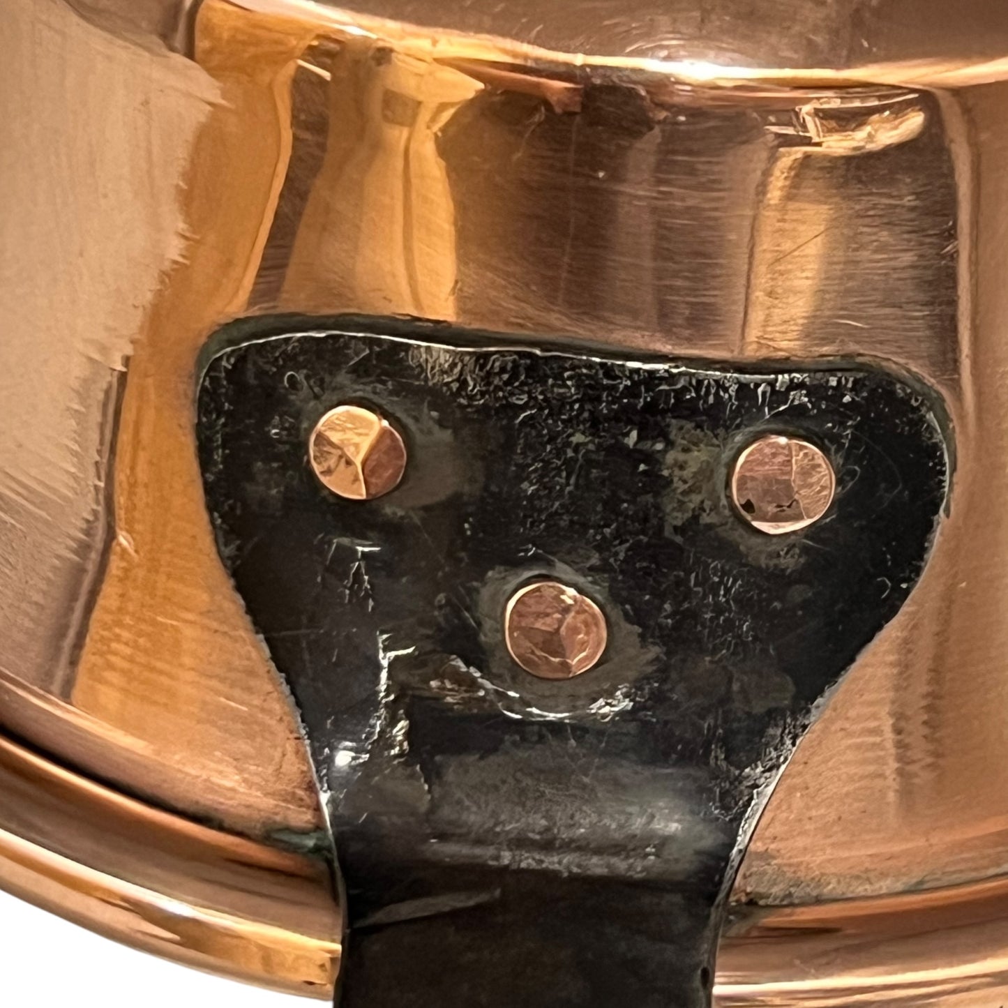 Close-up of a copper pan with a black handle on a white background