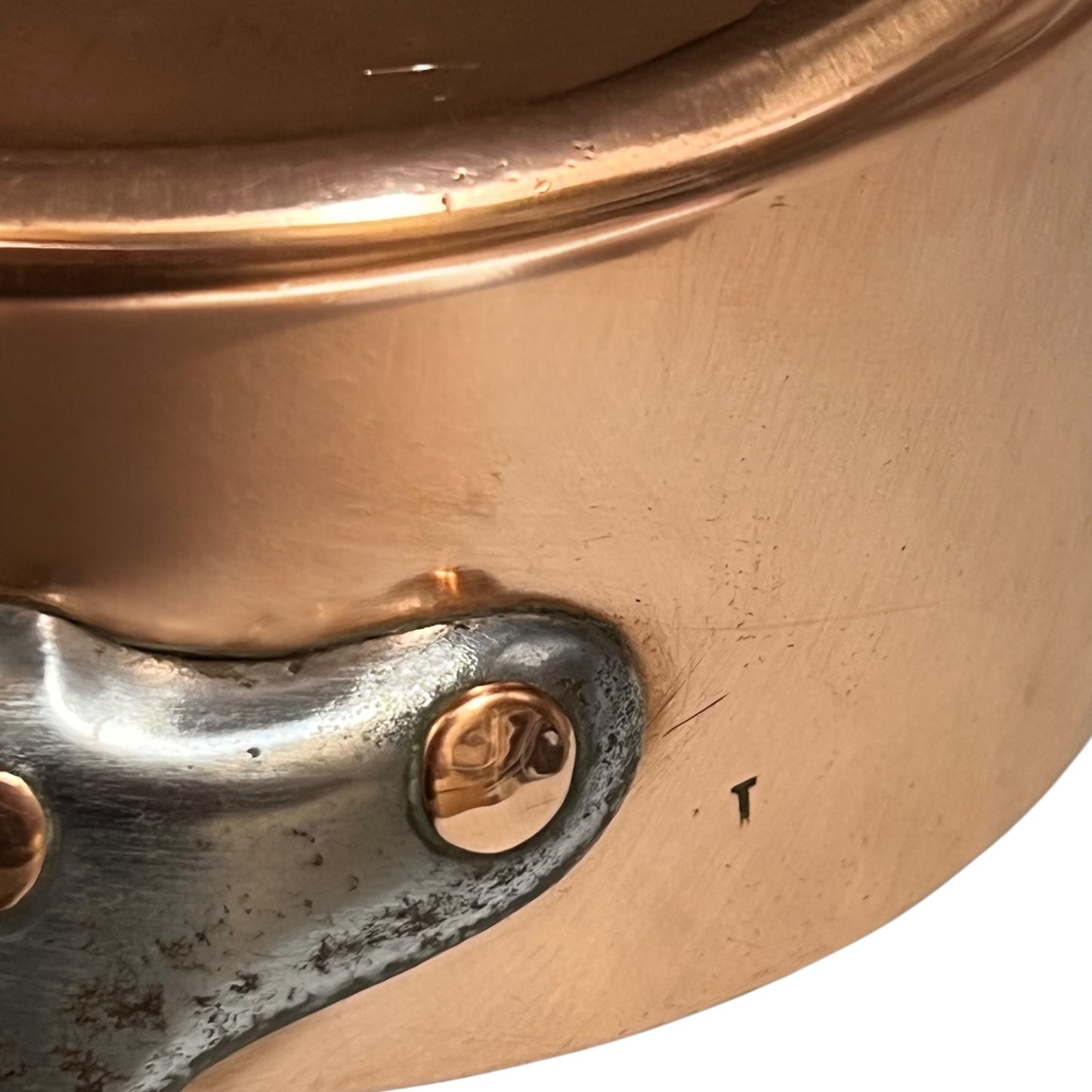 cast iron handle and copper rivets of copper pan