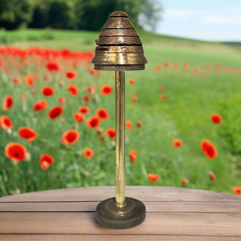 WW1 brass fuse in a garden of poppies on a table