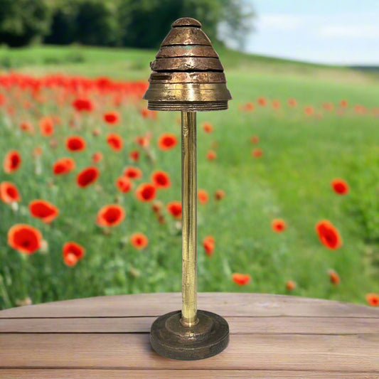WW1 brass fuse in a garden of poppies on a table