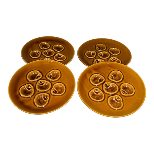 Four brown ceramic plates with decorative patterns on a white background