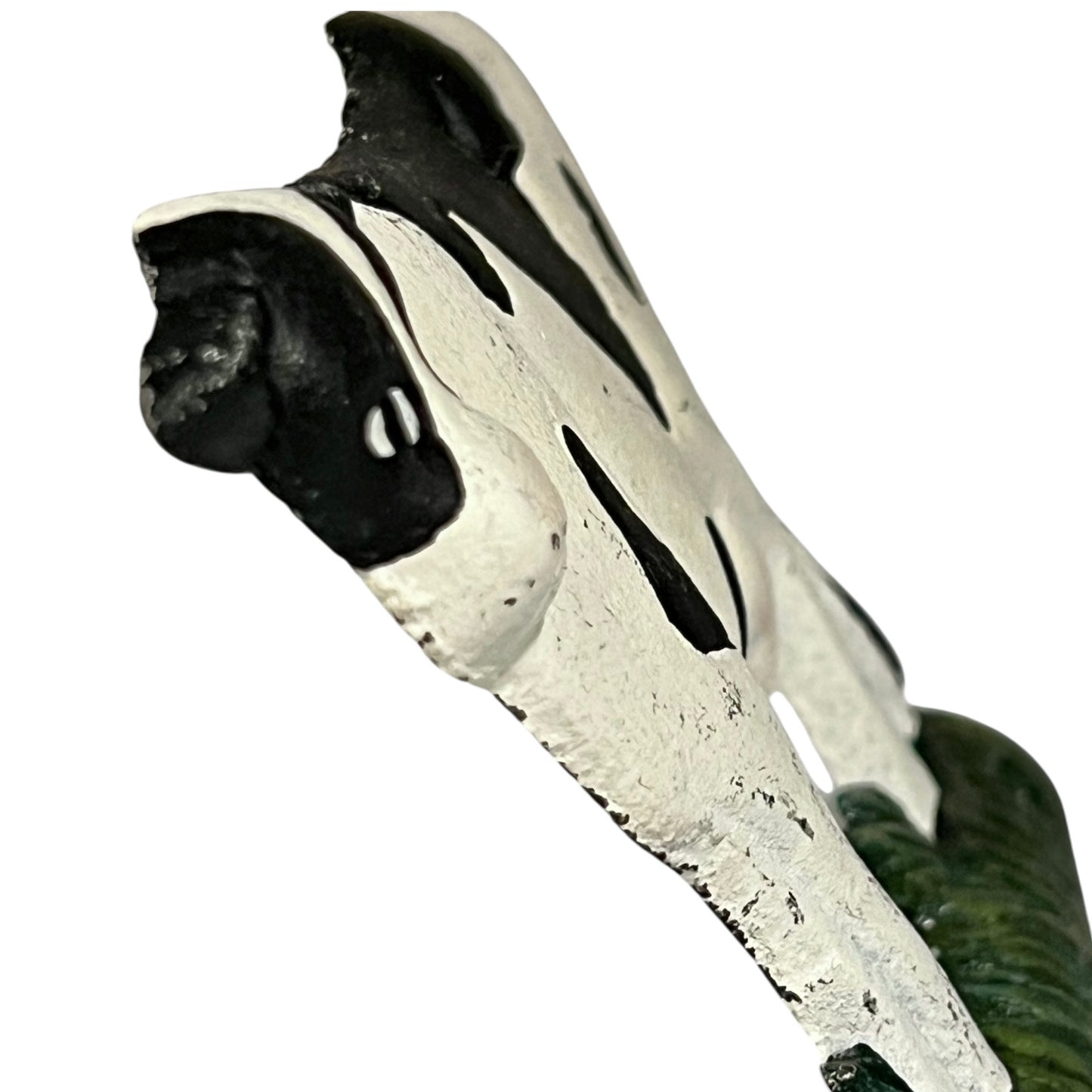 Close up of cow toilet paper holder with black and white pattern on a white background