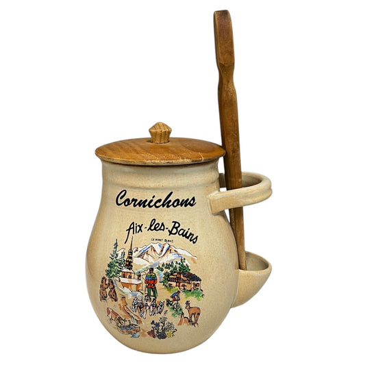 Decorative jar with wooden handle and lid, featuring illustrations and text on a white background