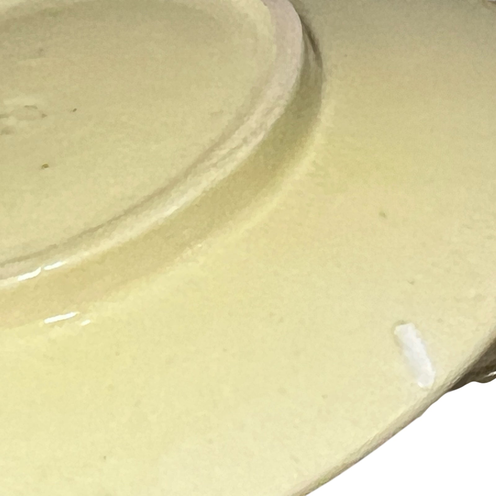 Close-up of a ceramic plate with a glossy beige finish