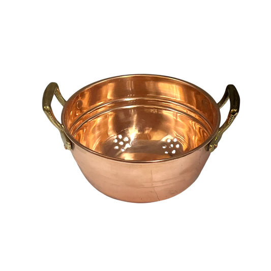 A copper colander with two brass handles and a perforated bottom, shown on a plain white background.