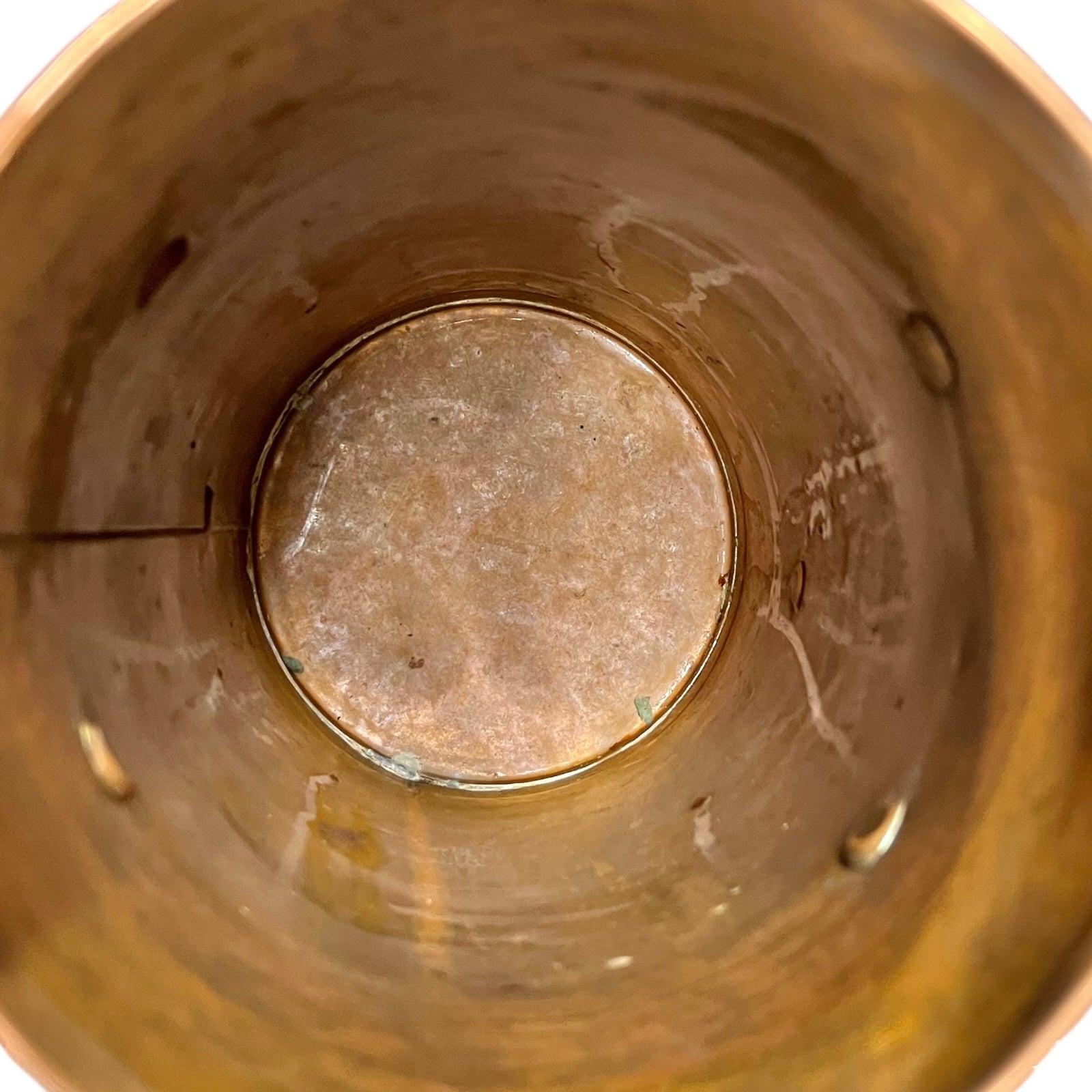 Close-up of a copper milk churn with a chain handle on a white background