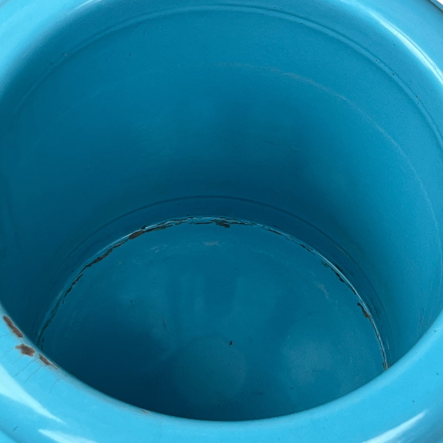Close up of blue metal bucket with a wooden handle on a white background