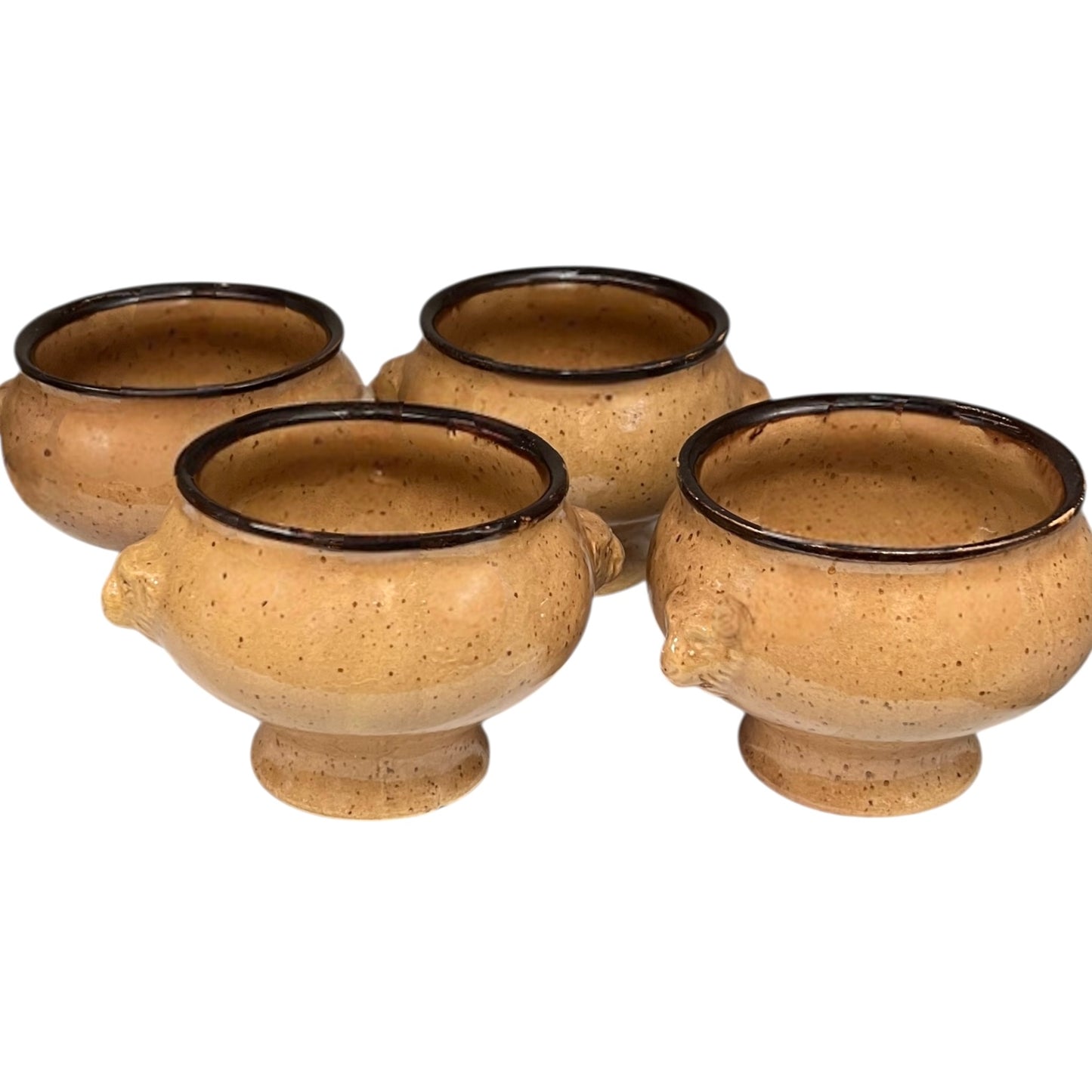 Set of four speckled beige lions head soup bowls with dark rims on a white background
