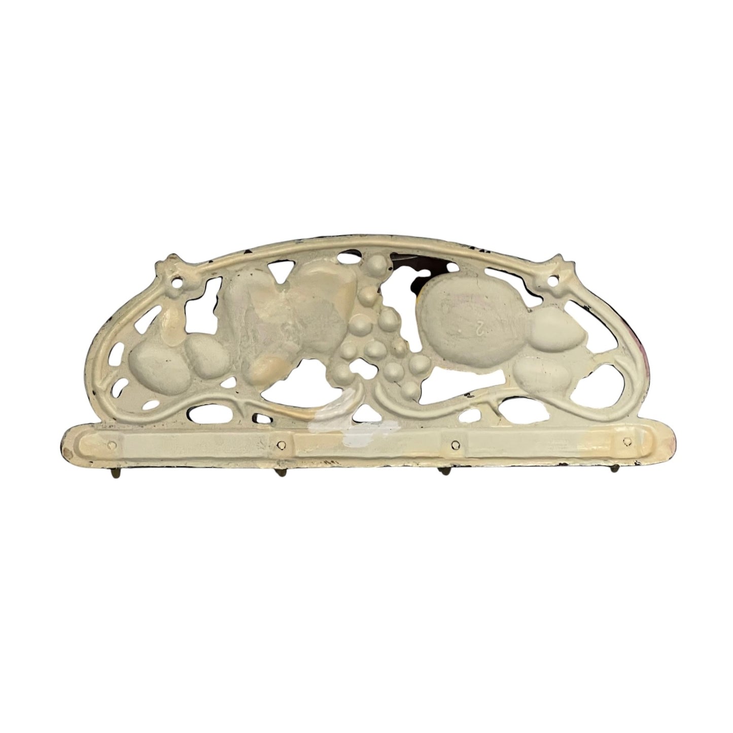 An ornate vintage metal wall plate or bracket with a decorative scrollwork design featuring grape and leaf motifs, finished in an aged cream or off-white color.