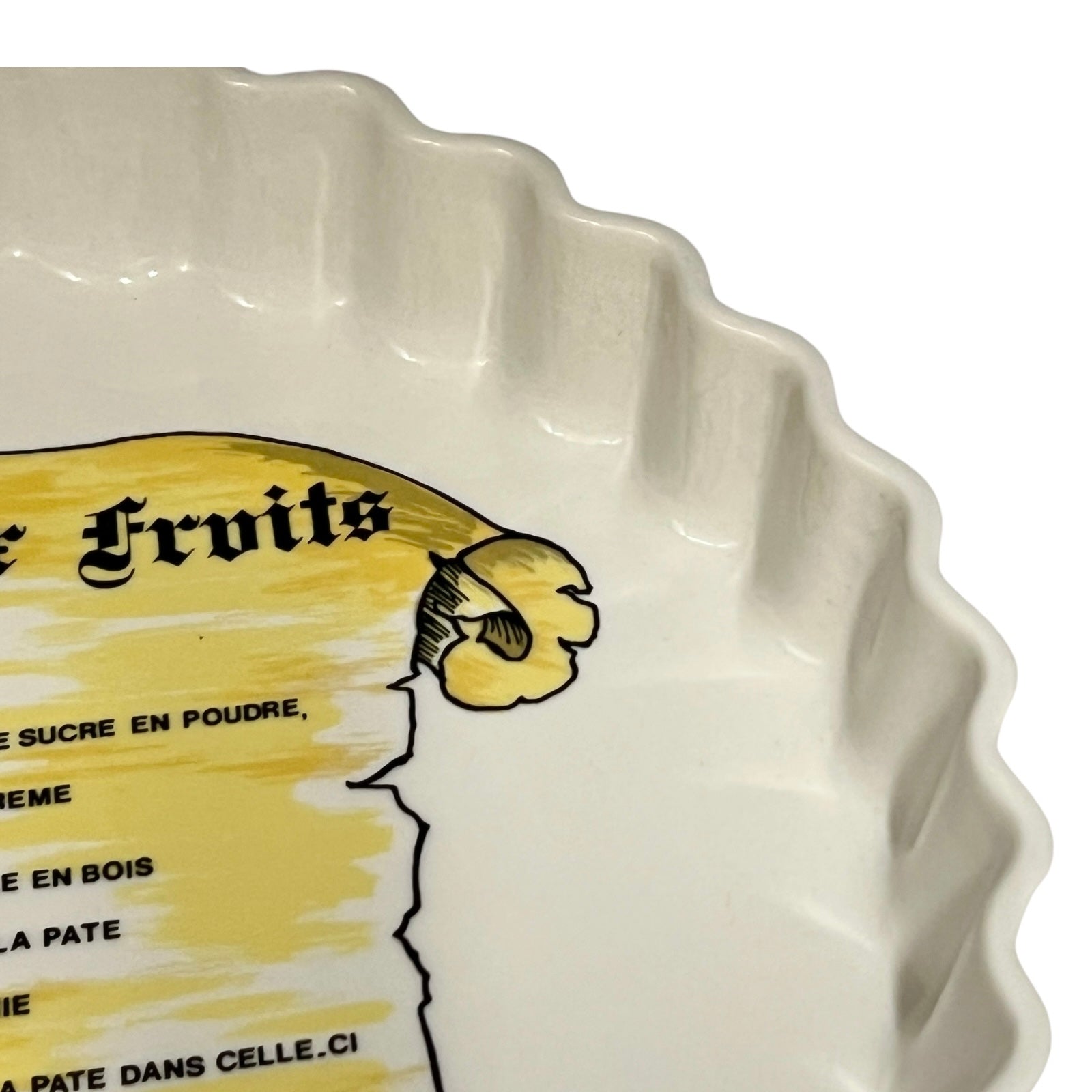 White ceramic pie dish with yellow label and fruit illustration on a white background