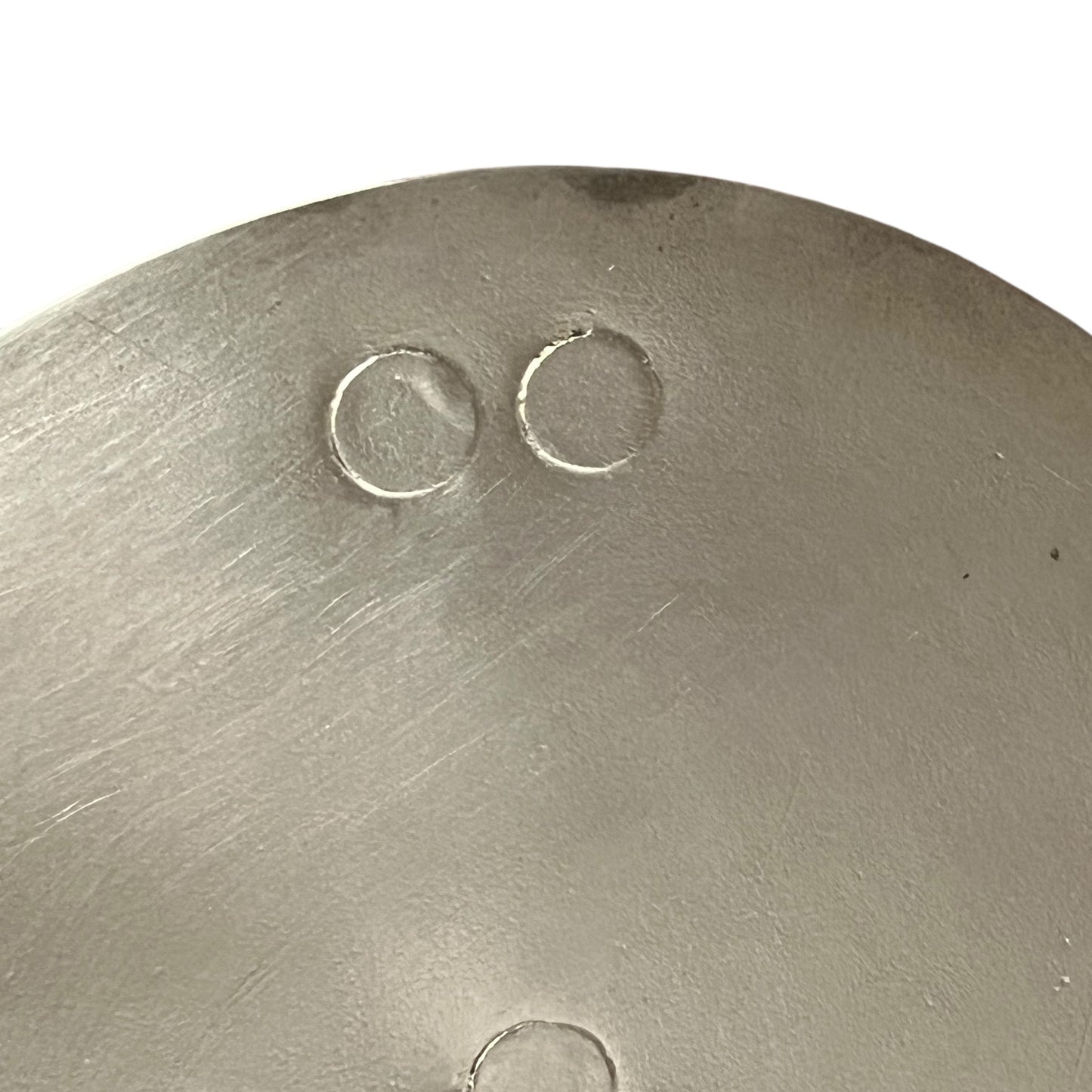 Close-up of a copper pan lid with brand new tin lining on a white background