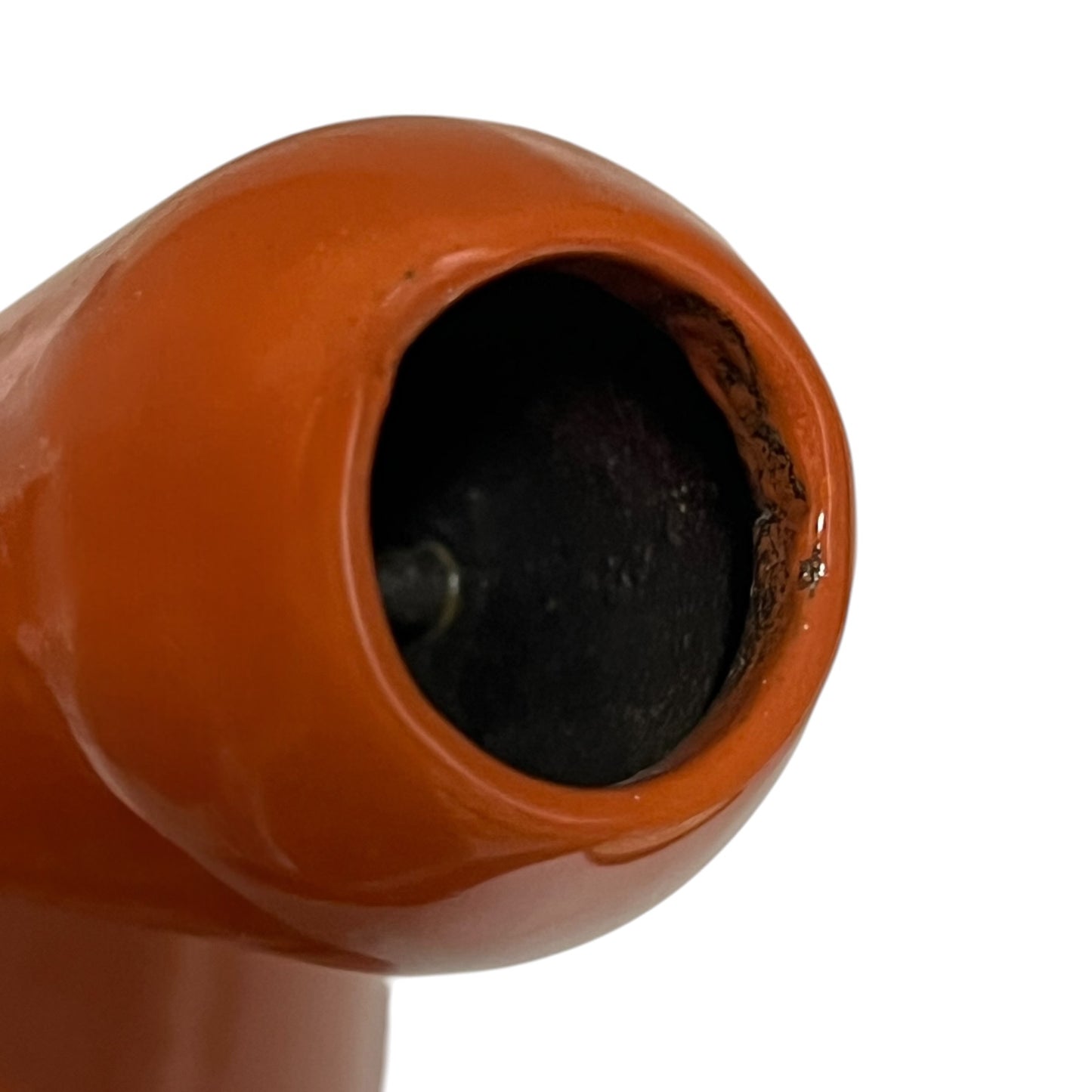 Close up of a rust coloured cast iron saucepan with lid on a white background