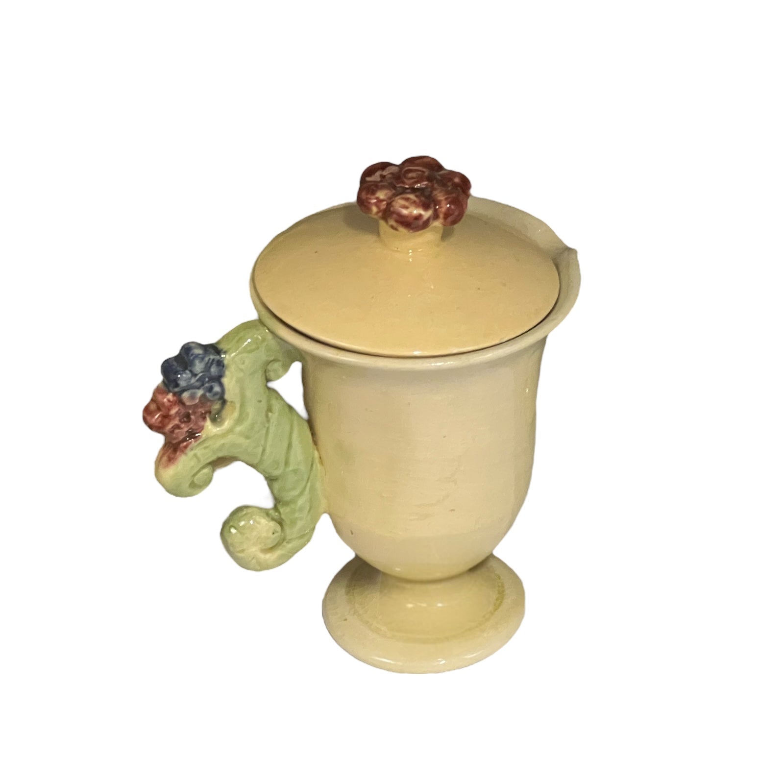 Decorative ceramic mug with lid and handle featuring fruit designs on a white background