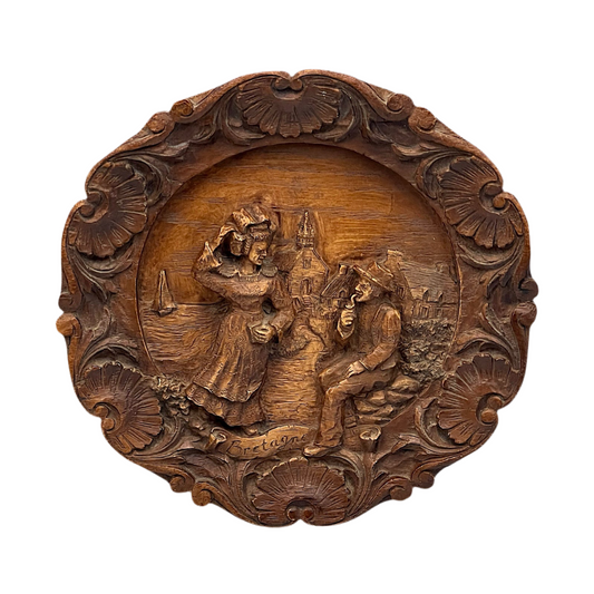 Wooden relief sculpture with intricate carvings on a white background