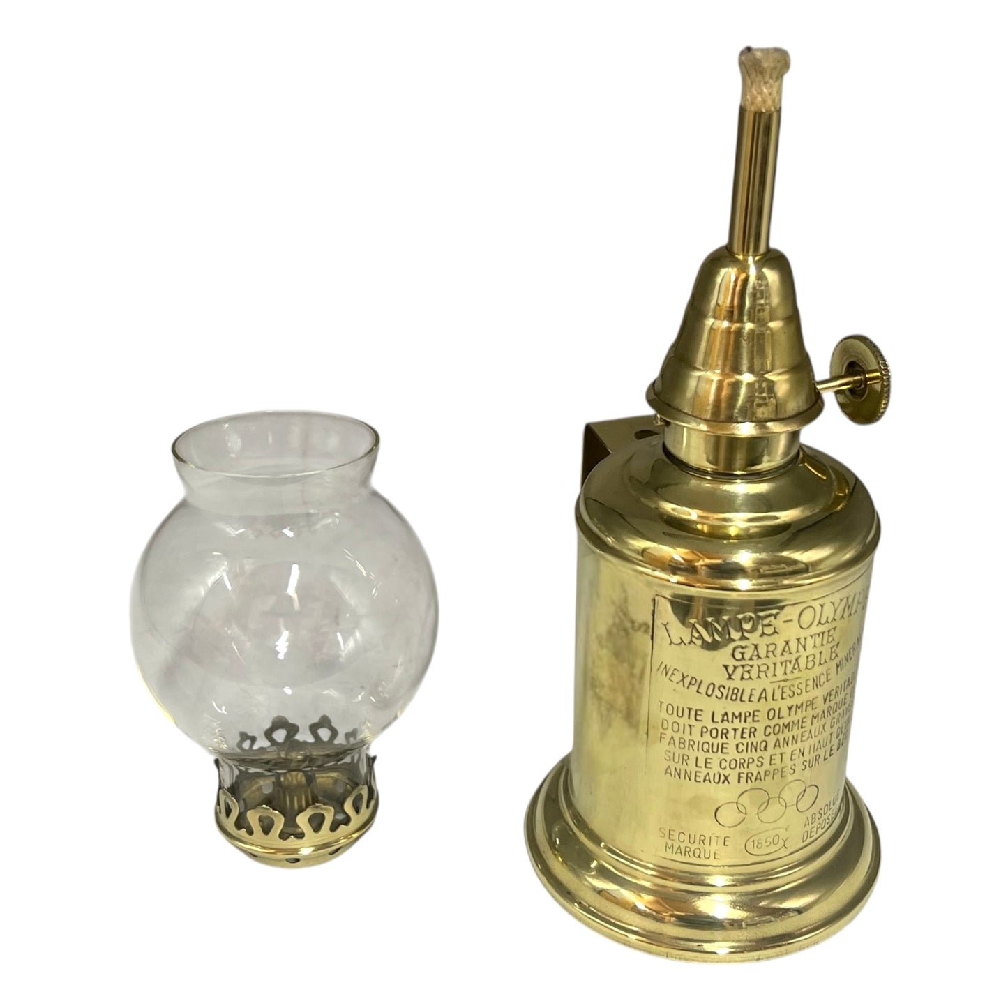 Brass oil lamp with clear glass shade on a white background