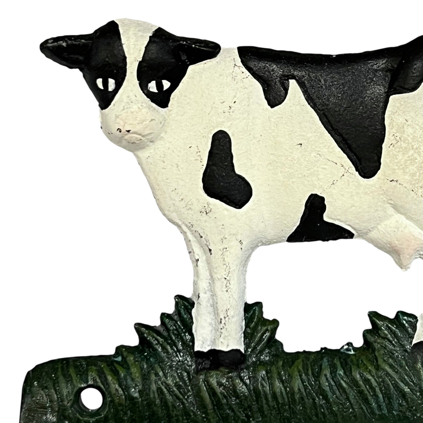 Close up of cow toilet paper holder with black and white pattern on a white background