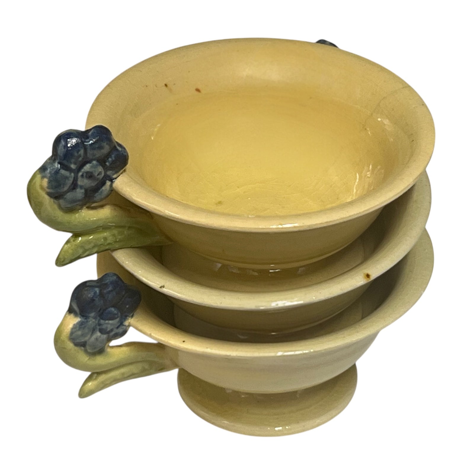Set of three ceramic cups with floral handles on a white background