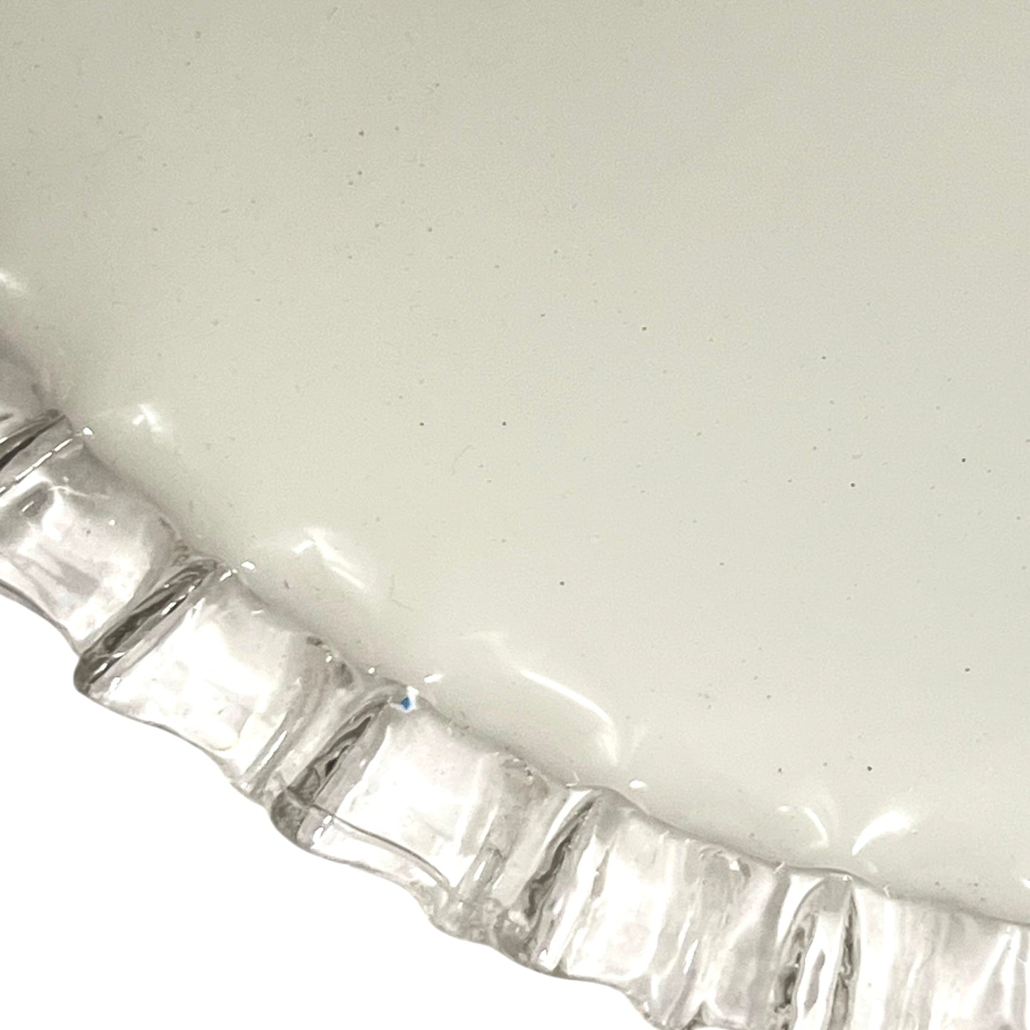 Close-up of a pendant light with white glass shade and brass fitting on a white background