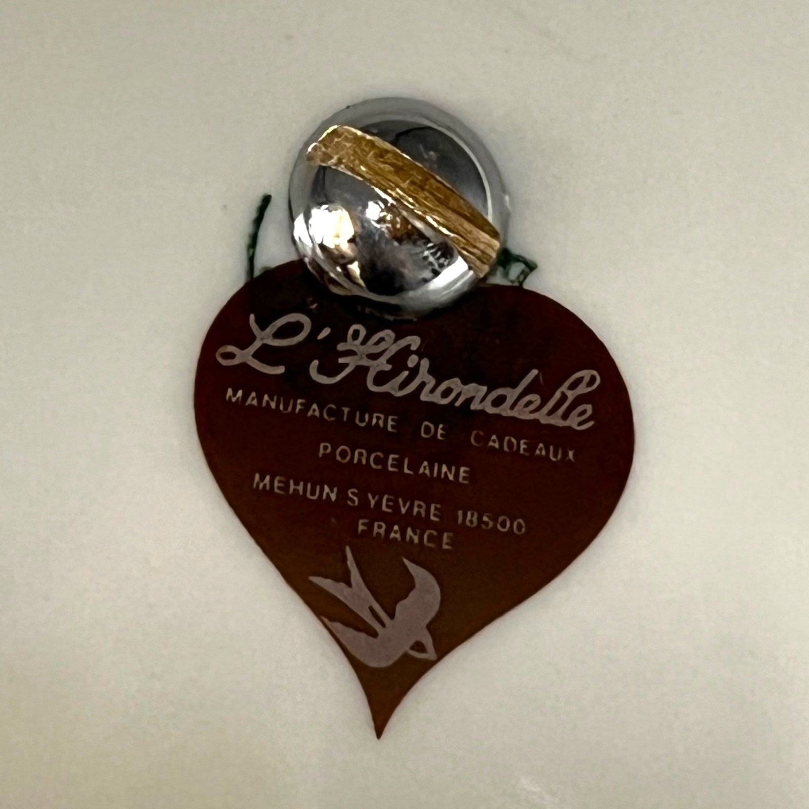 Heart-shaped tag with 'L'Heironde' branding on a white background