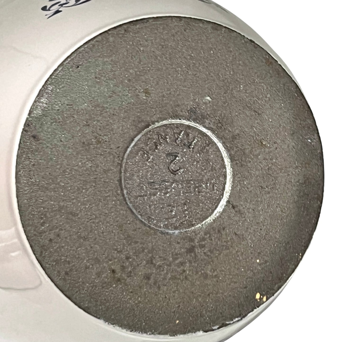 Close up of a Le Creuset pot base on a white background