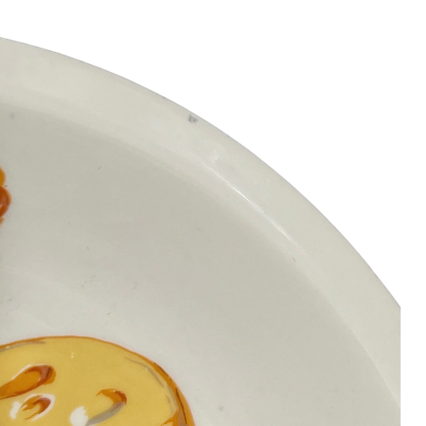Close-up of a ceramic plate with a cheese design on a white background