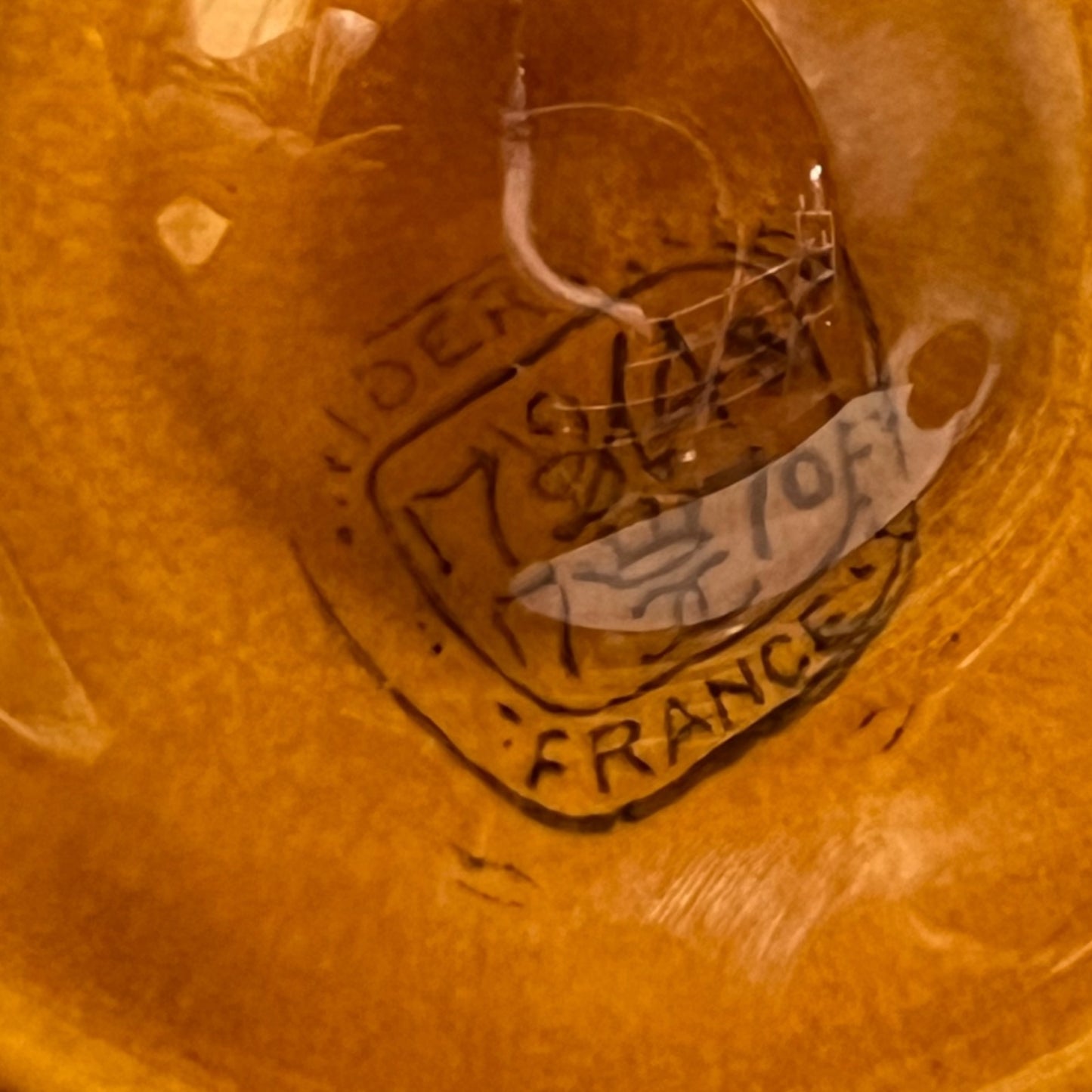 Close-up of a vintage item with 'Made in France' engraving on a brown background