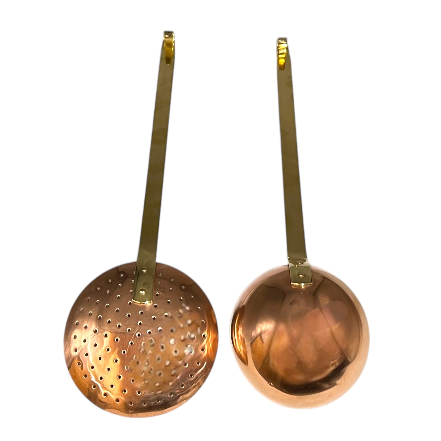 Set of 2 French copper utensils with long brass handles, includes a straining spoon and a ladle on a white background
