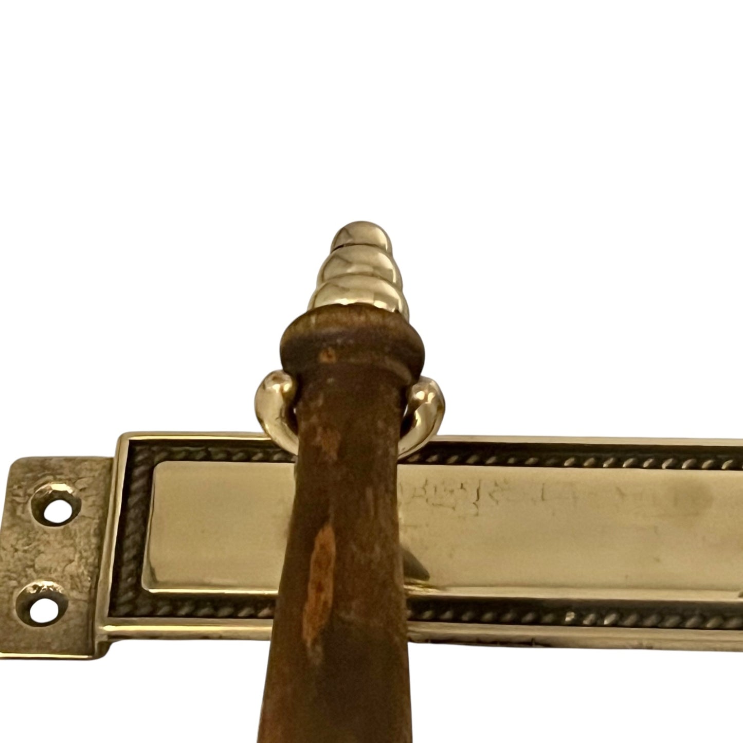 wooden handle on brass utensil with a white background