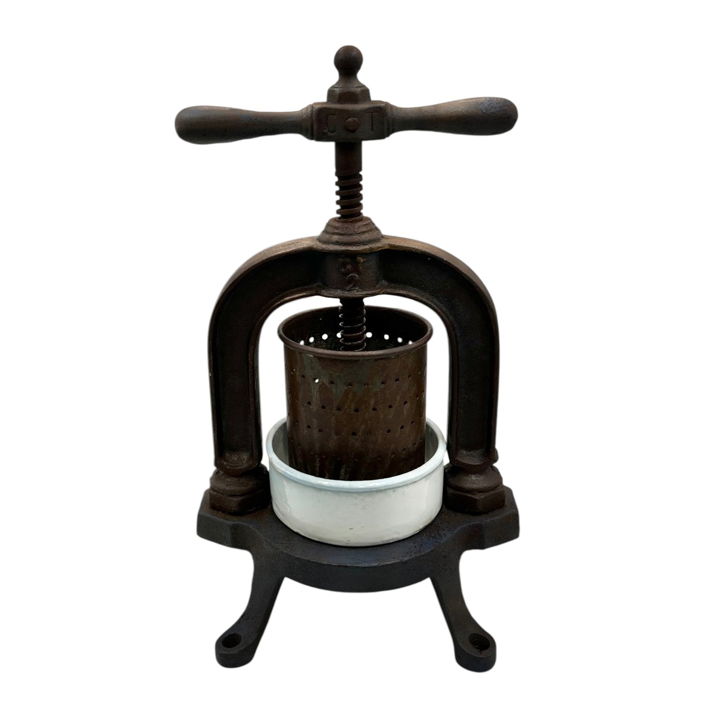 Vintage French cast iron metal fruit press with a white enamel container on a white background