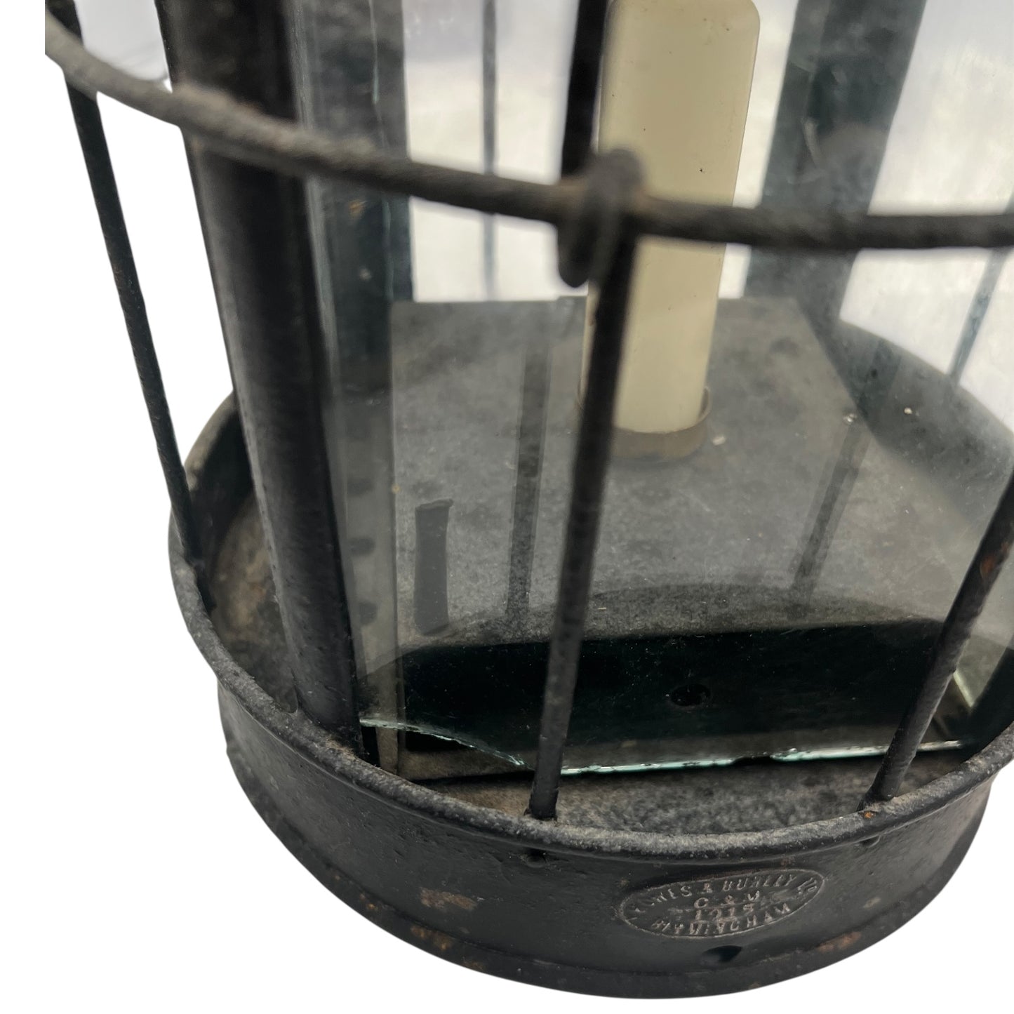 Close-up of a black metal lantern with glass panels on a white background
