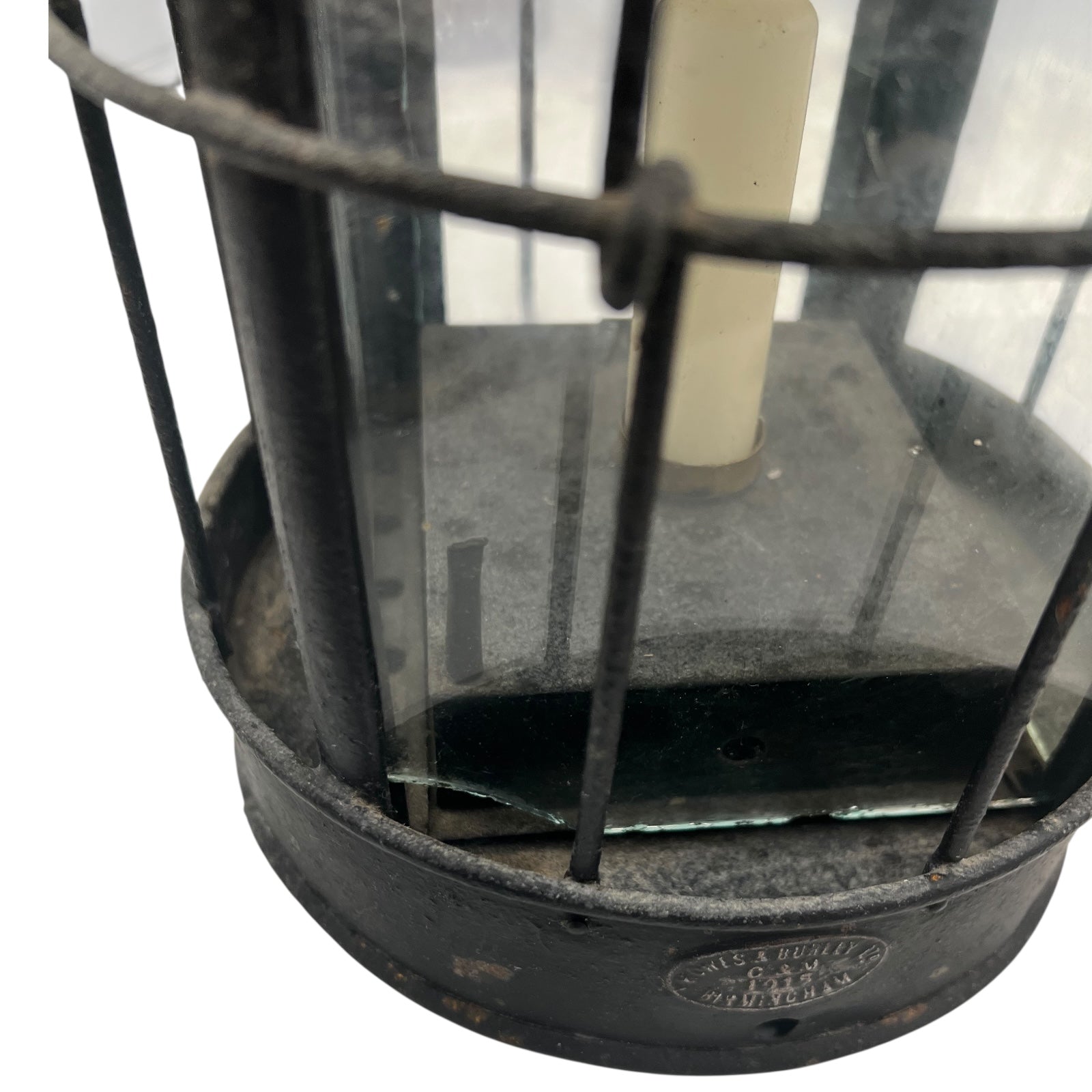 Close-up of a black metal lantern with glass panels on a white background