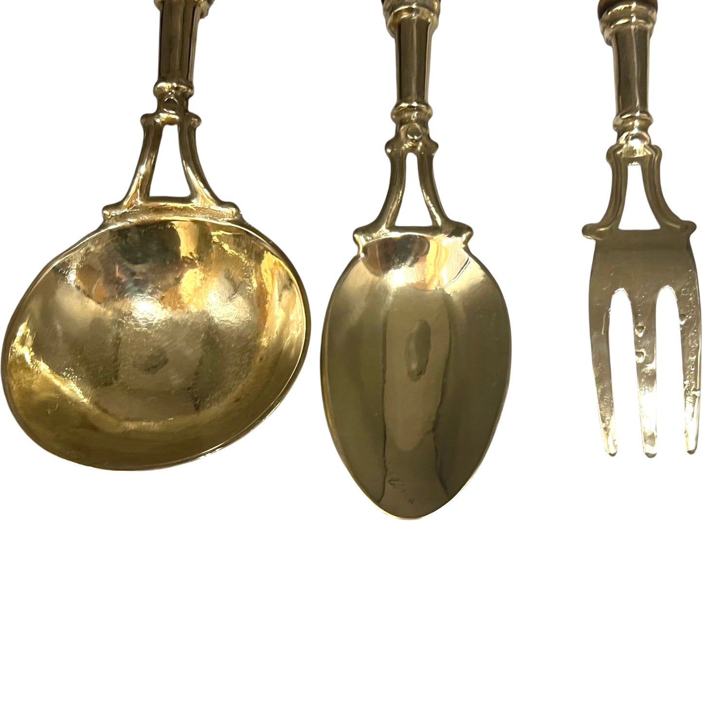 Set of gold-colored spoons and a fork on a white background