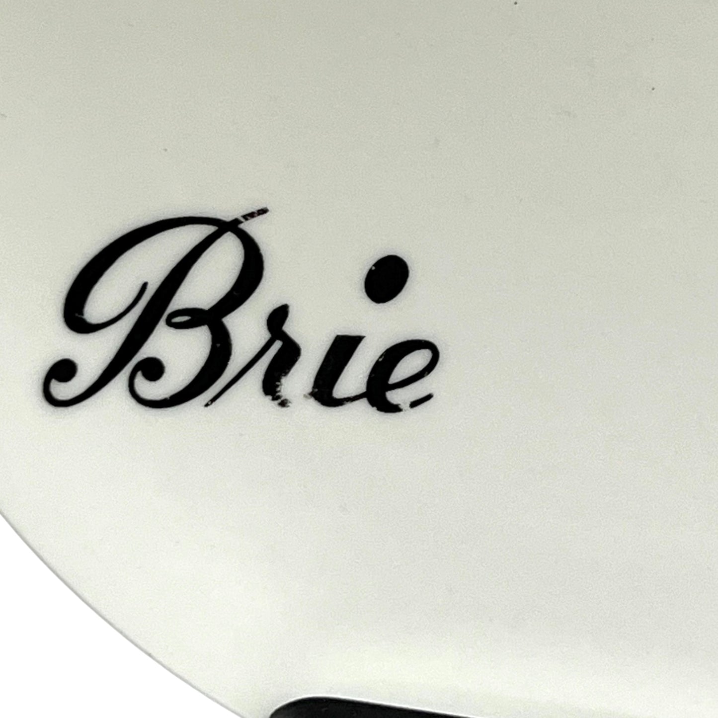 White cheese plate with 'Brie' text in black on a white background