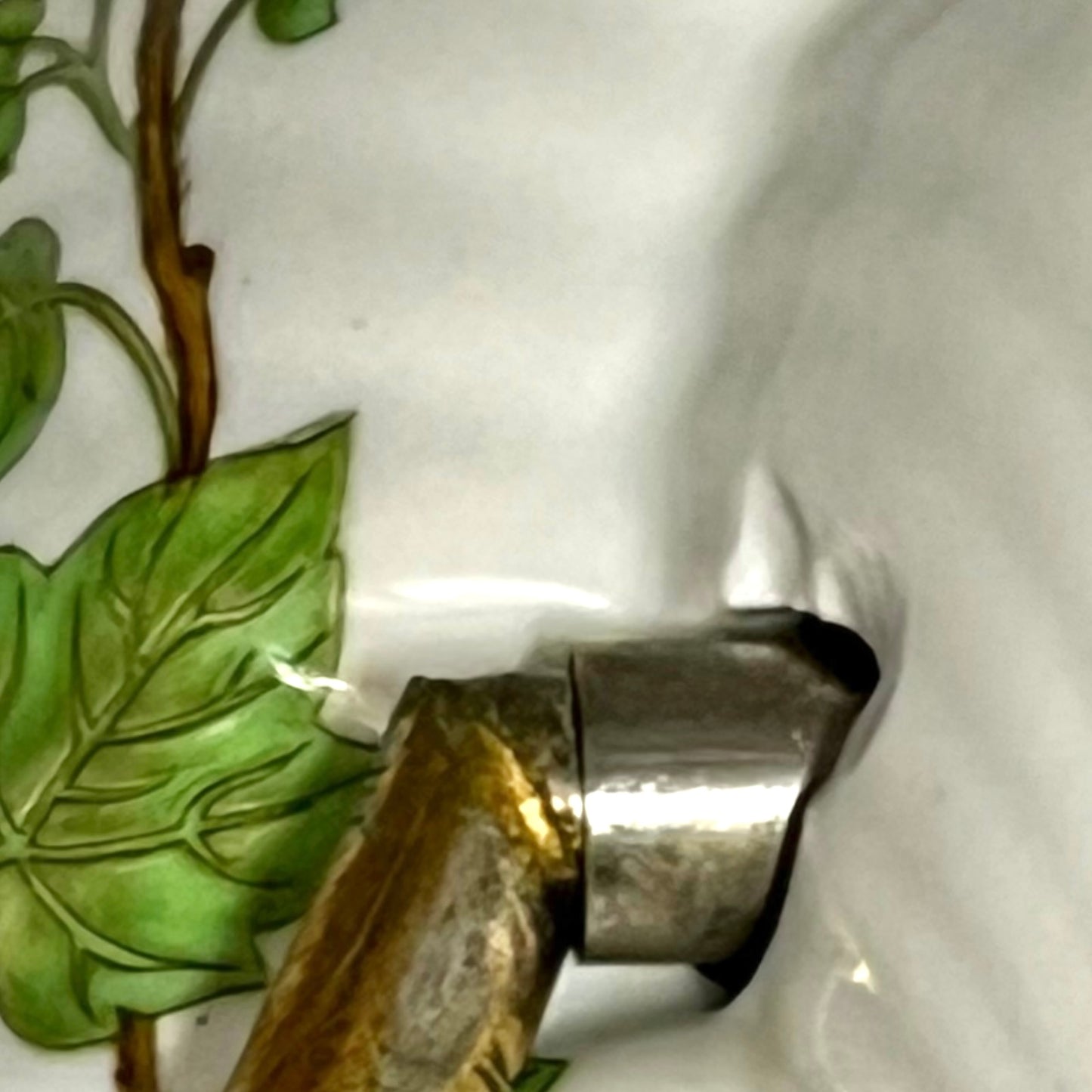 close up of towel hoop with leaf design on a white background