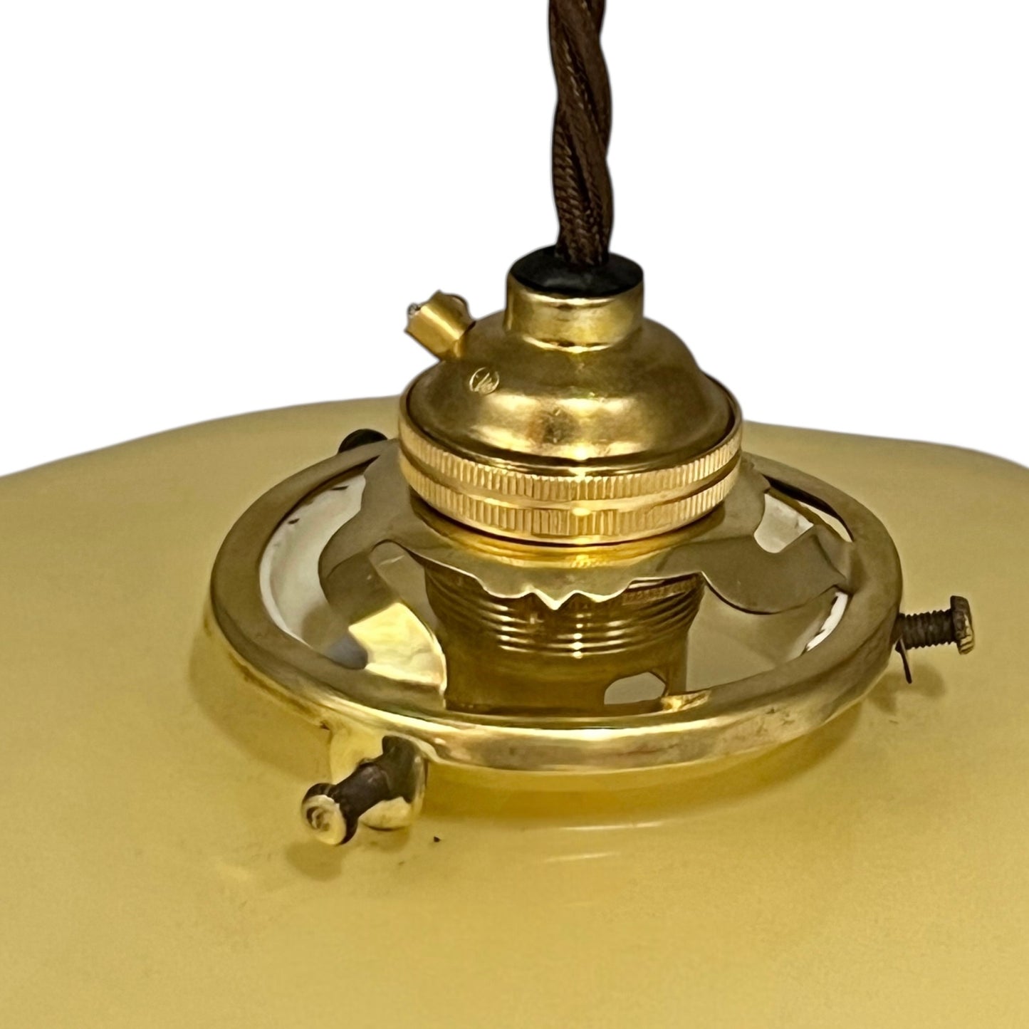 Vintage-style pendant light with a yellow glass shade and brass fitting on a white background