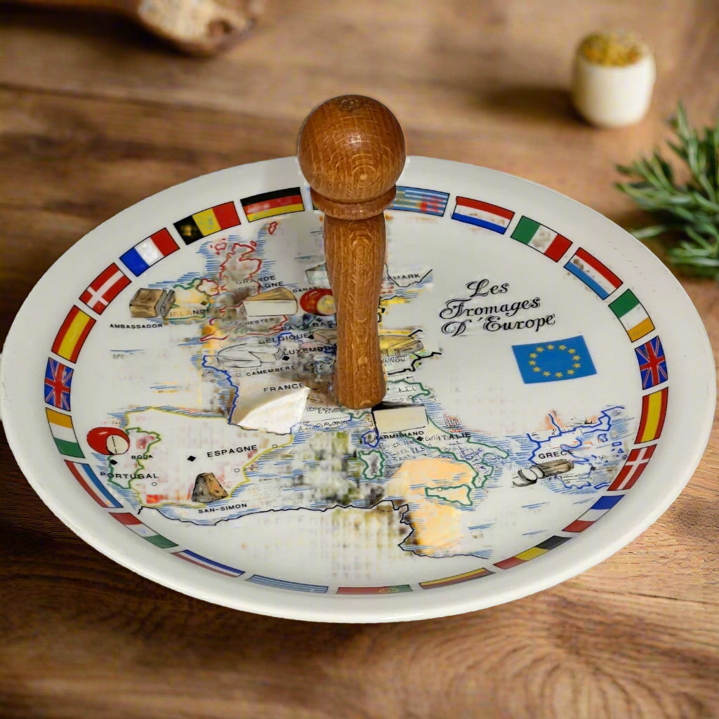 Decorative cheese plate with a map of Europe and wooden handle on a wooden table with a rustic  background
