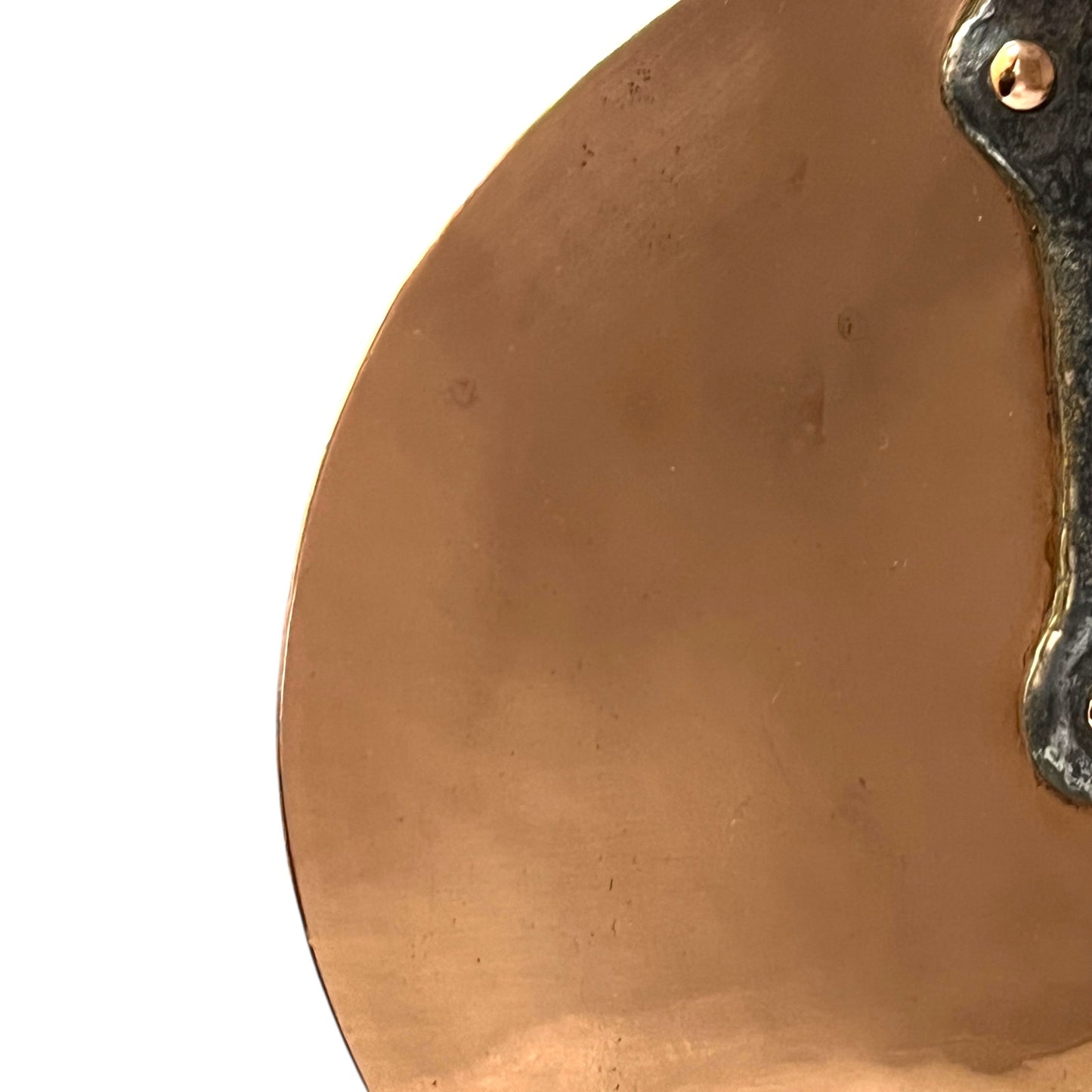 Close-up of a copper pan lid on a white background
