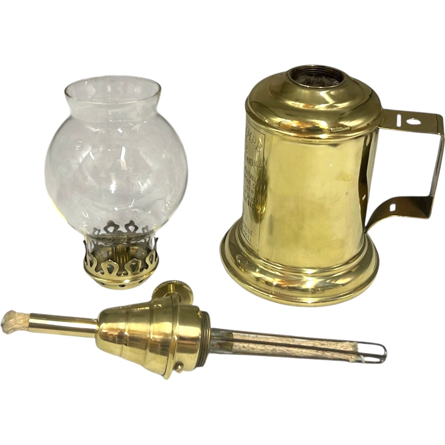 Brass oil lamp with clear glass chimney and metal wick trimmer on a white background