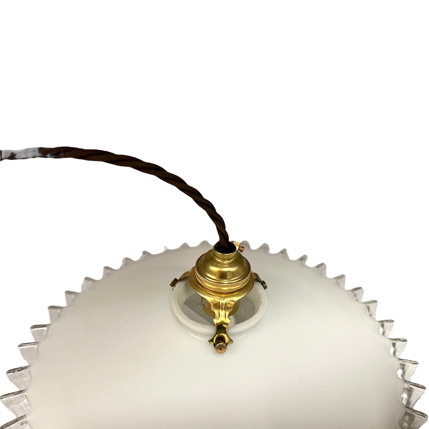 Close-up of a pendant light with white glass shade and brass fitting on a white background