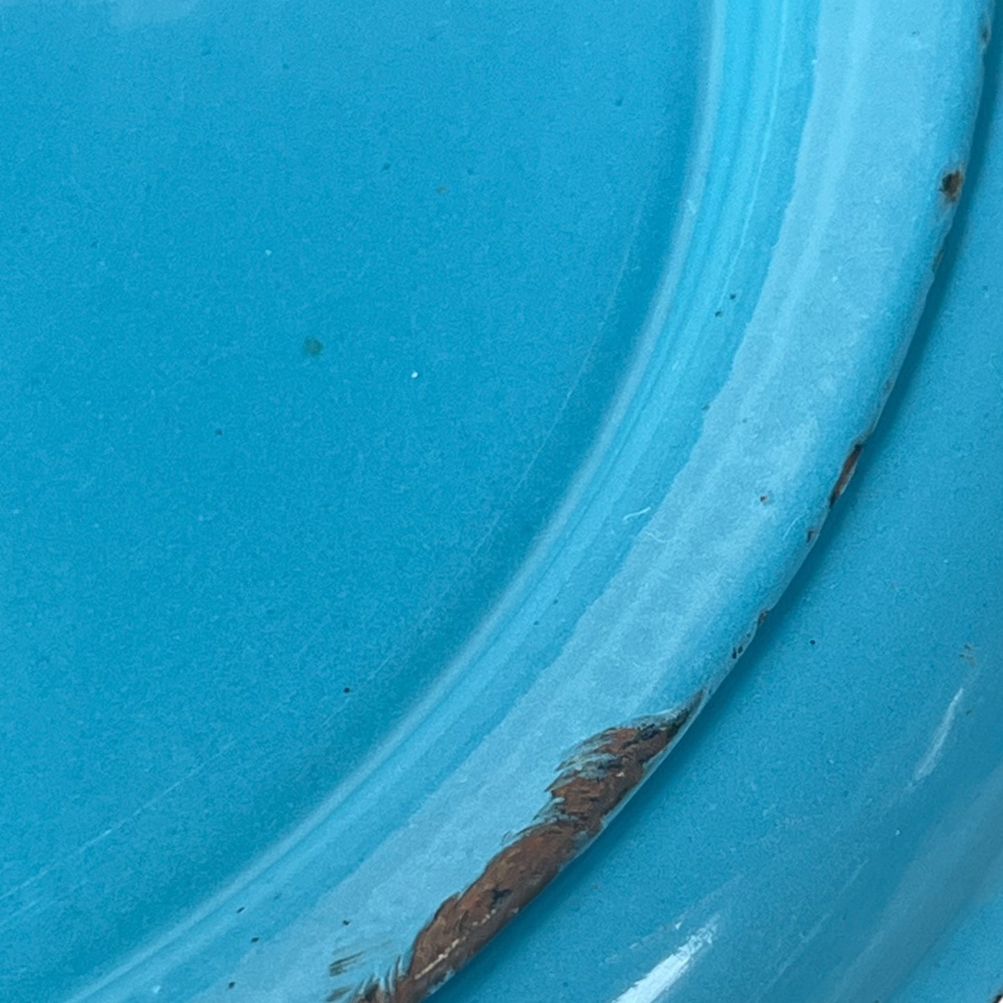 Close up of blue metal bucket with a wooden handle on a white background