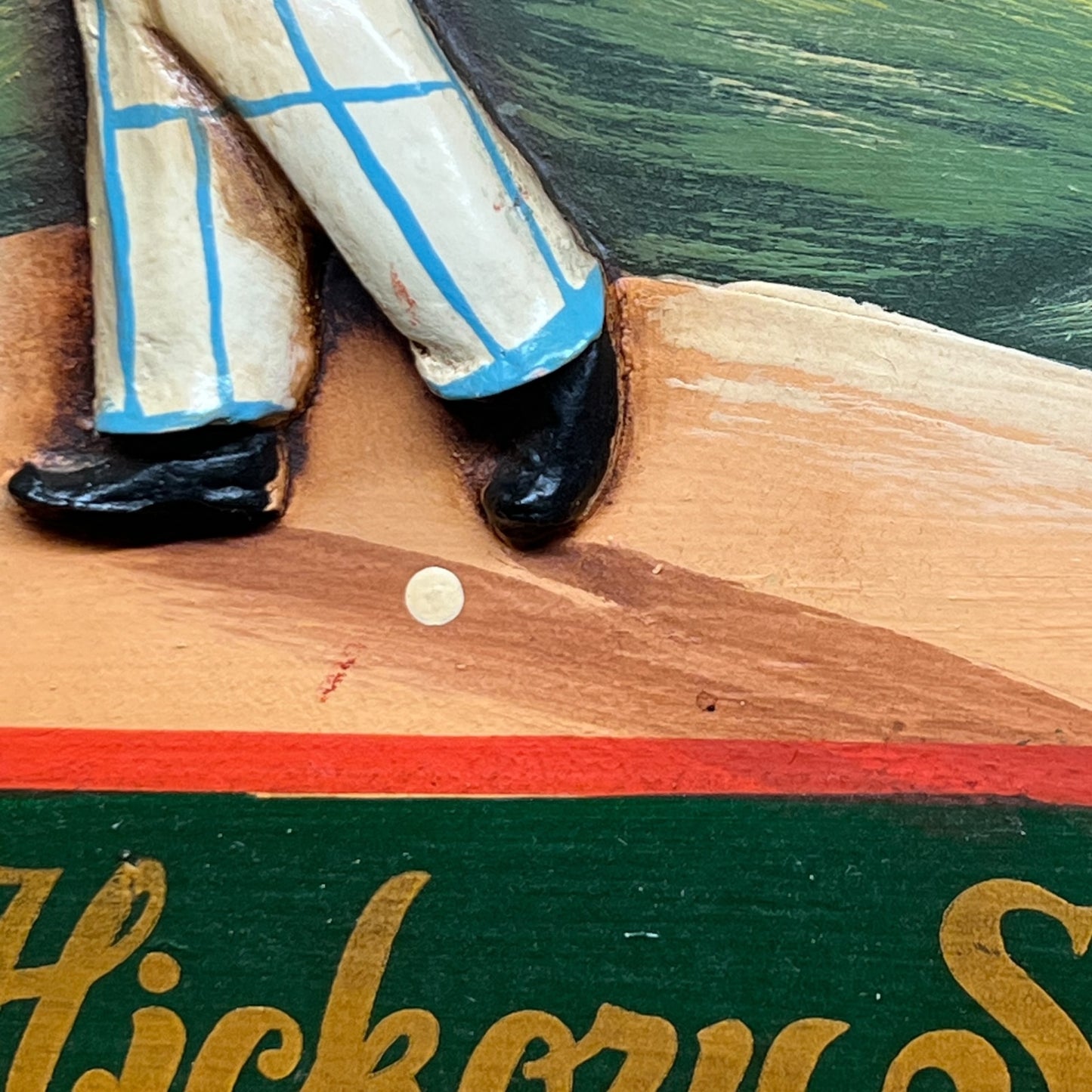 Close-up of a person's feet in checkered socks on a wooden surface with a green background.