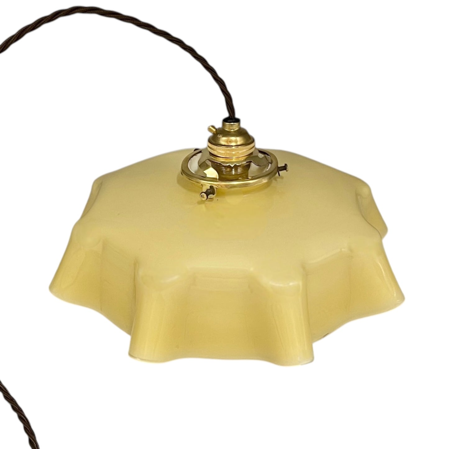 Vintage-style pendant light with a yellow glass shade and brass fitting on a white background