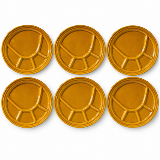 Six round mustard-yellow ceramic plates with a segmented, divided design, arranged in two rows of three on a white background.