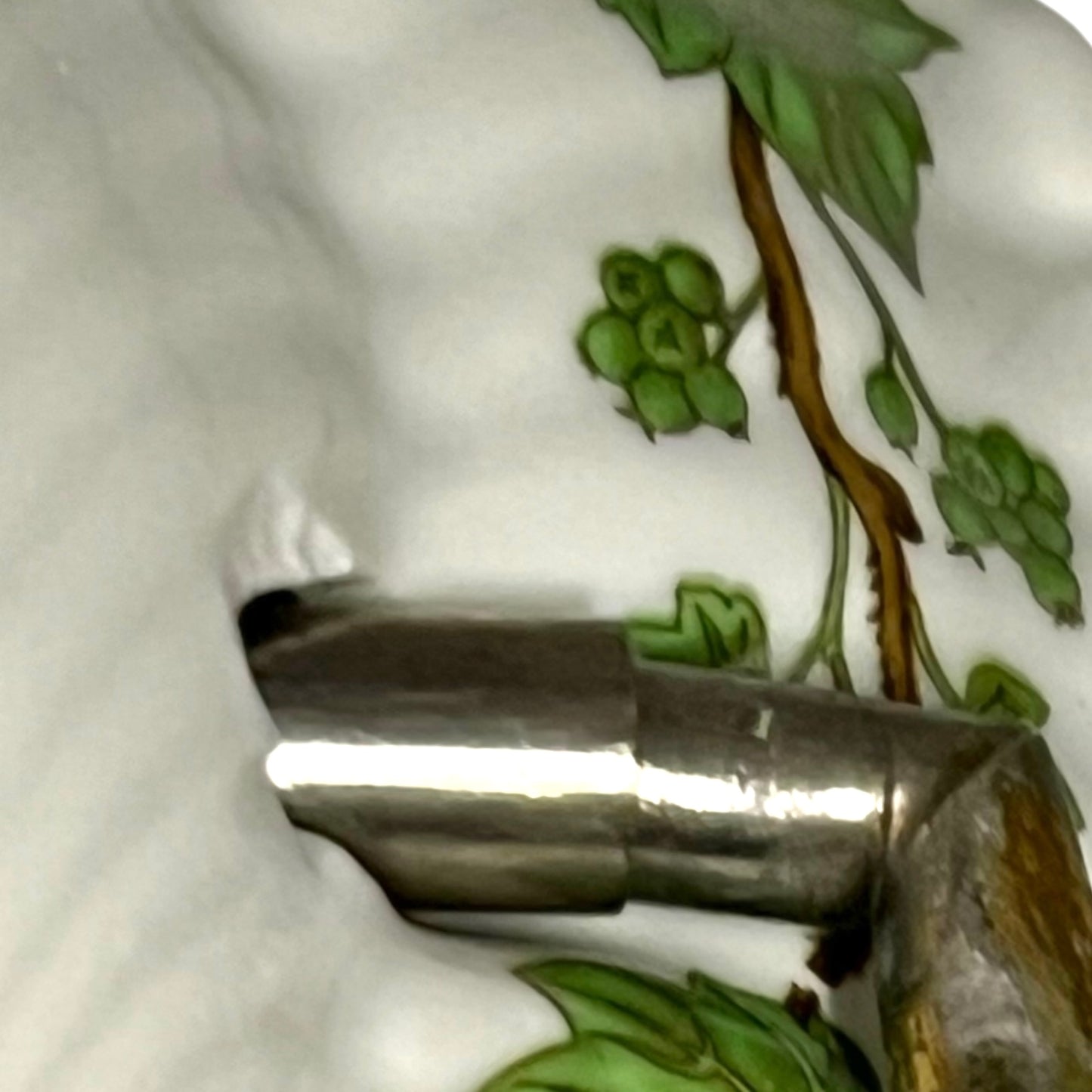 close up of towel hoop with leaf design on a white background