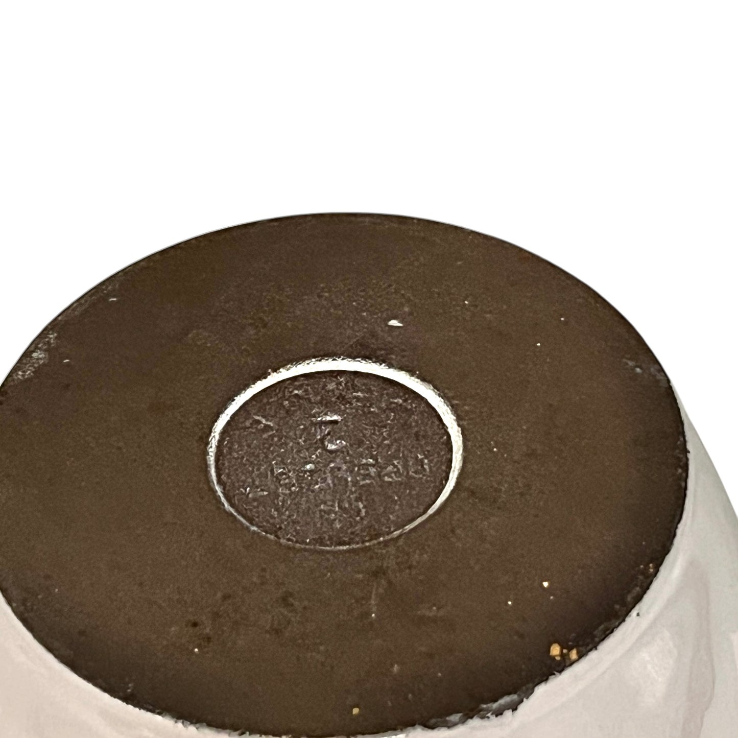 Close up of a Le Creuset pot base on a white background