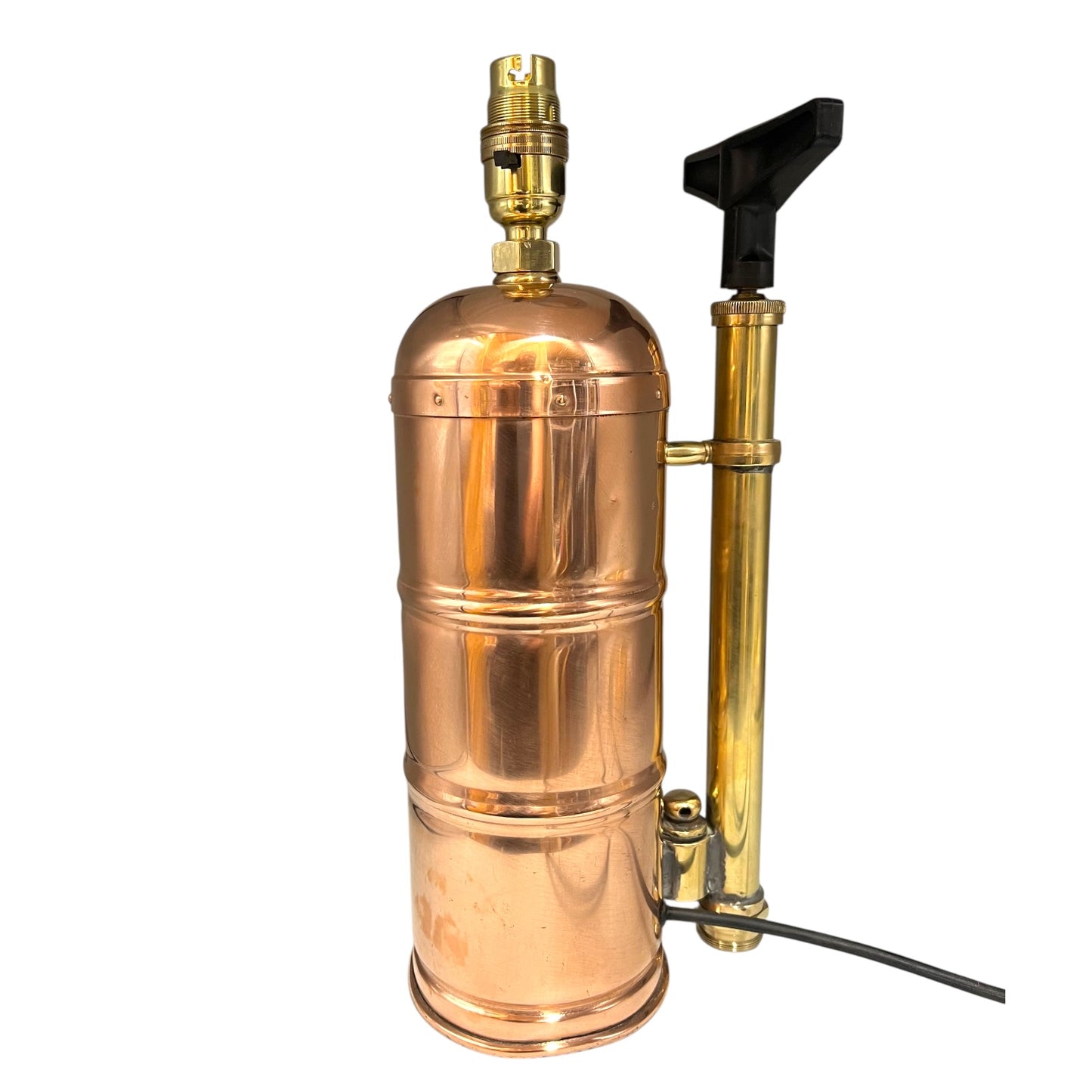 Copper and brass lamp with a black handle on a white background