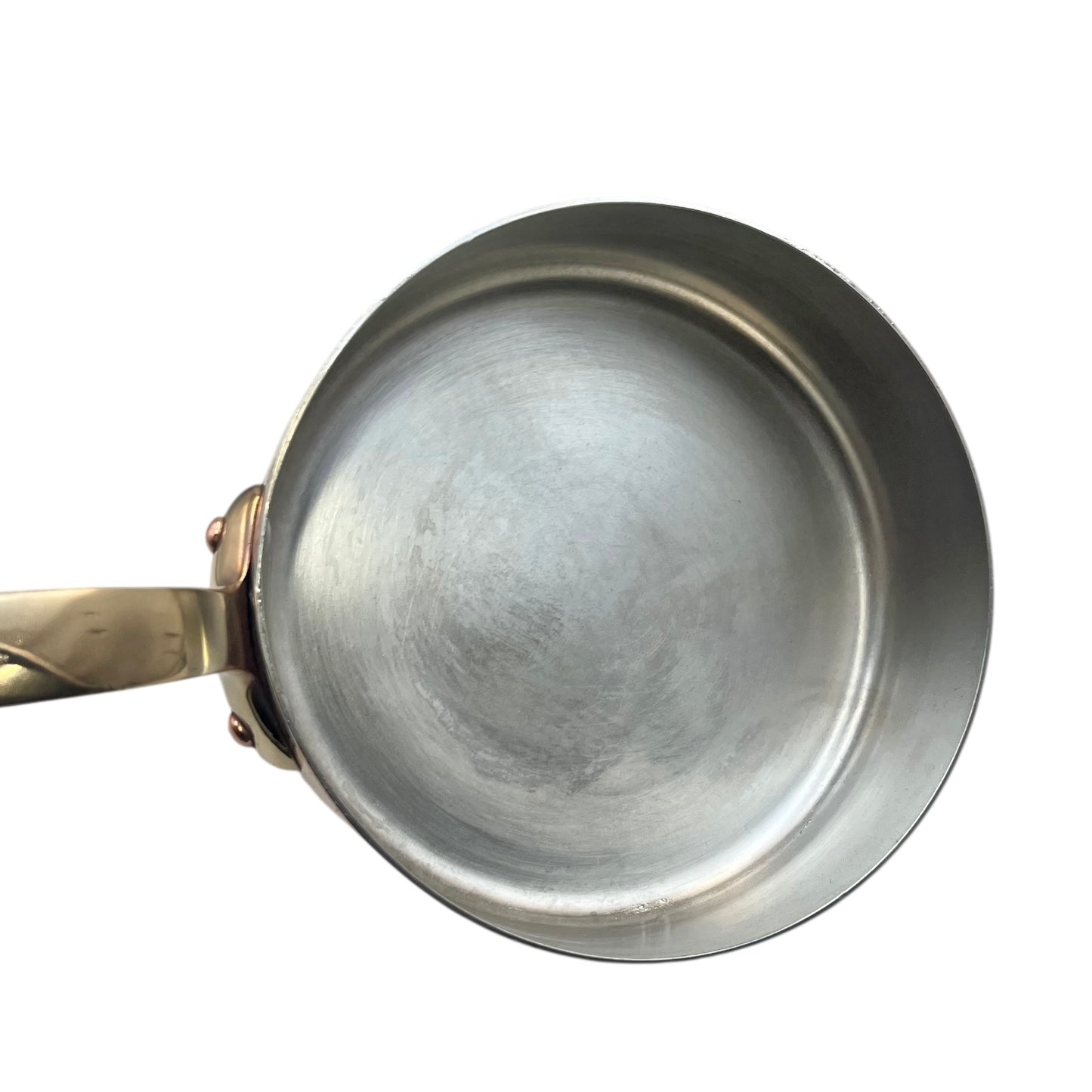 Small copper frying pan with a brass handle and tin lining on a white background